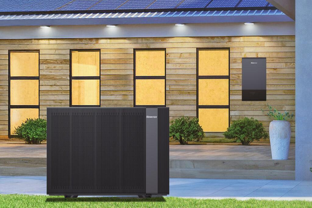 Wärmepumpe von Newntide im Vordergrund vor Haus, an Haus-Holzfassade hängt das Controlmodul