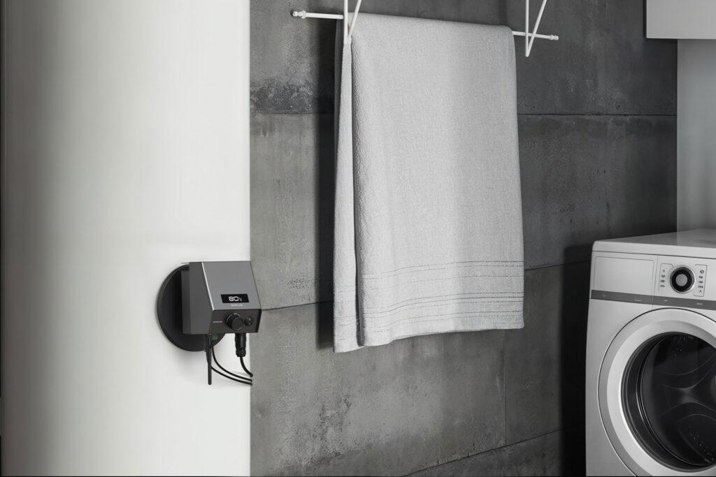 Ecoflow Powerglow an Wasserboiler im Badezimmer, daneben sieht man ein Handtuch und eine Waschmaschine.